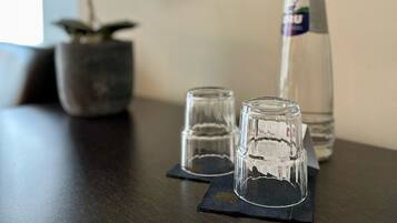 A table with two clear glasses and a water bottle.