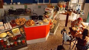 Ein Hotel-Frühstücksbereich mit Buffet, einschließlich verschiedener Speisen und Getränke.