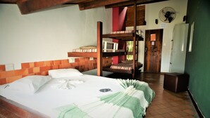Ein Etagenbett mit weißer Matratze und Kissen, einer grünen Decke und einem Holzkopfteil.