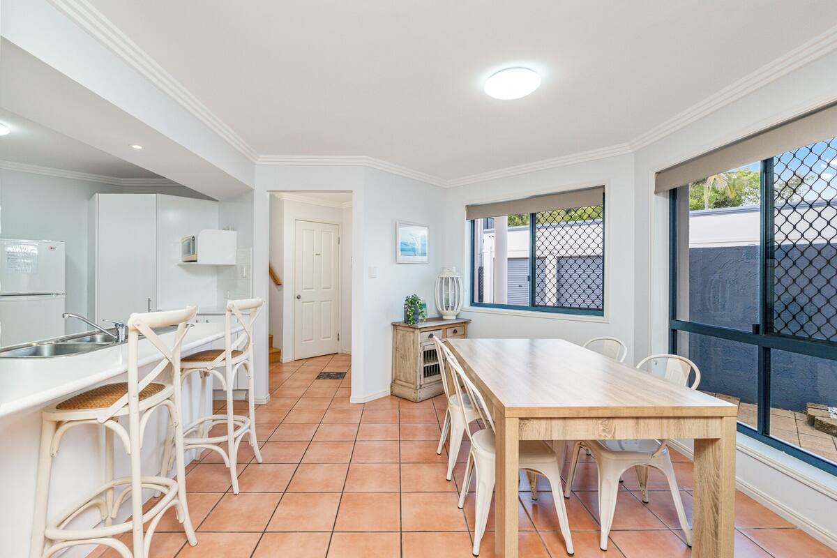 A kitchen with white cabinets, a dining table, and chairs.