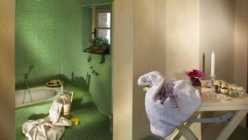 Bathroom features a green-tiled wall, white bathtub, and a small window.