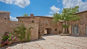 A courtyard with stone walls, a tiled floor, and potted plants. - Borgo della Marmotta - Farm Home (Spoleto)