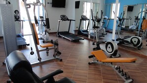 A gym with various exercise equipment, including treadmills, stationary bikes, and weight machines. - Al Baglio - Affittacamere (Palermo)