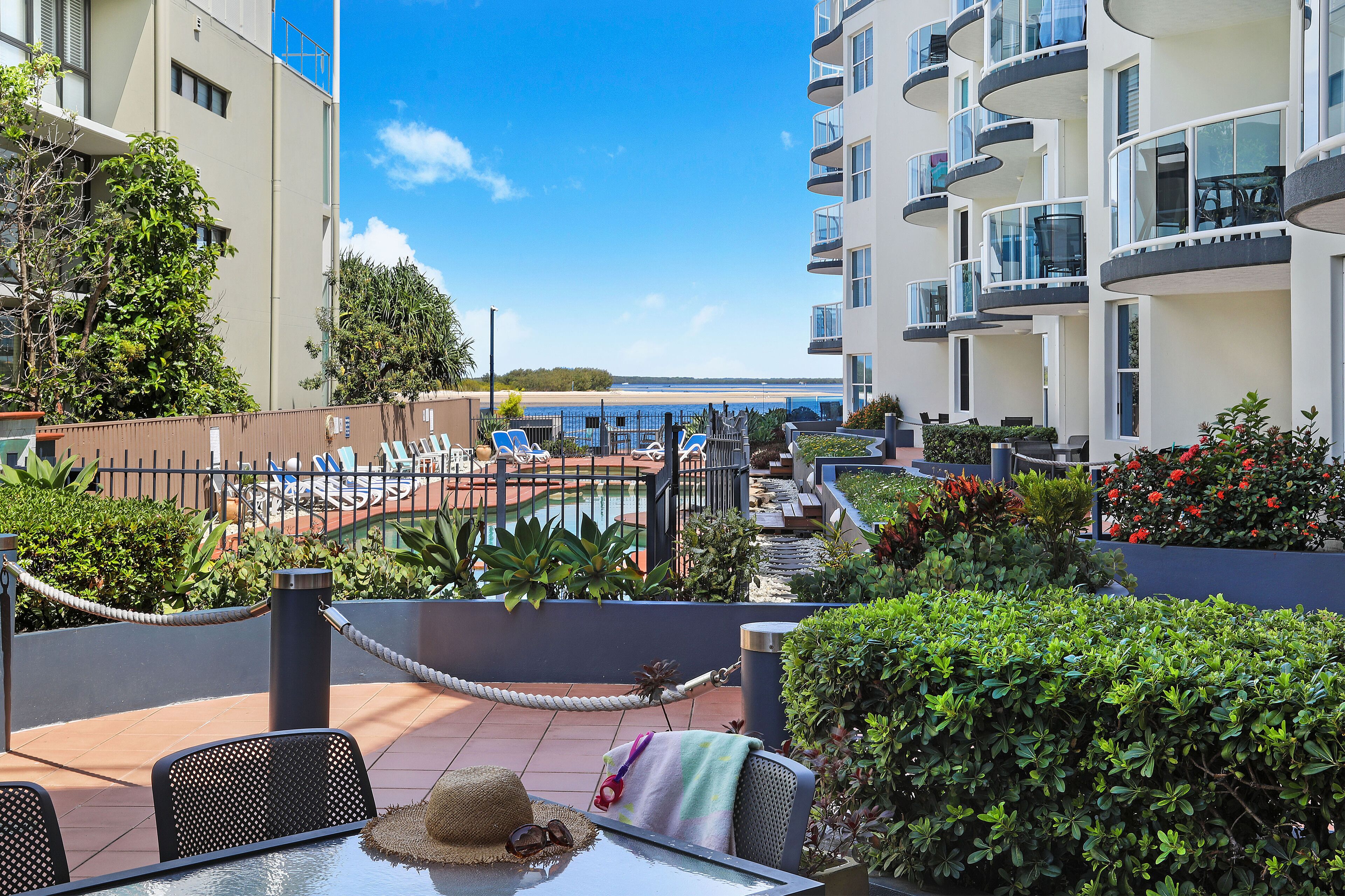 A rooftop terrace with a pool, lounge chairs, and a view of the sea.
