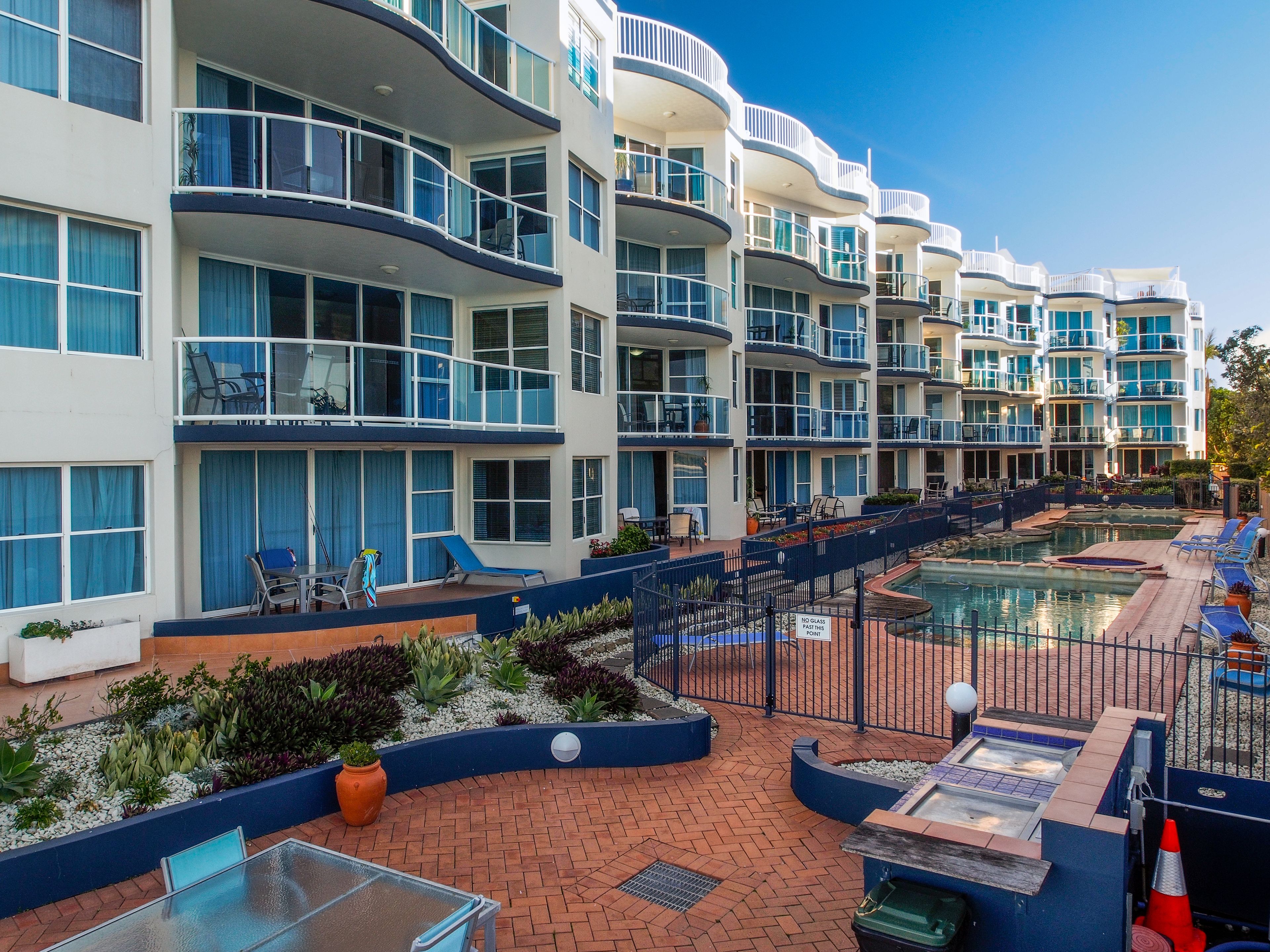 Un hôtel doté de nombreux balcons, d’une piscine et d’espaces de détente en plein air.