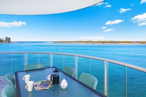 A table with a magazine, coffee pot, and cups on a balcony with a view of the sea. - Watermark Resort Caloundra (Caloundra)