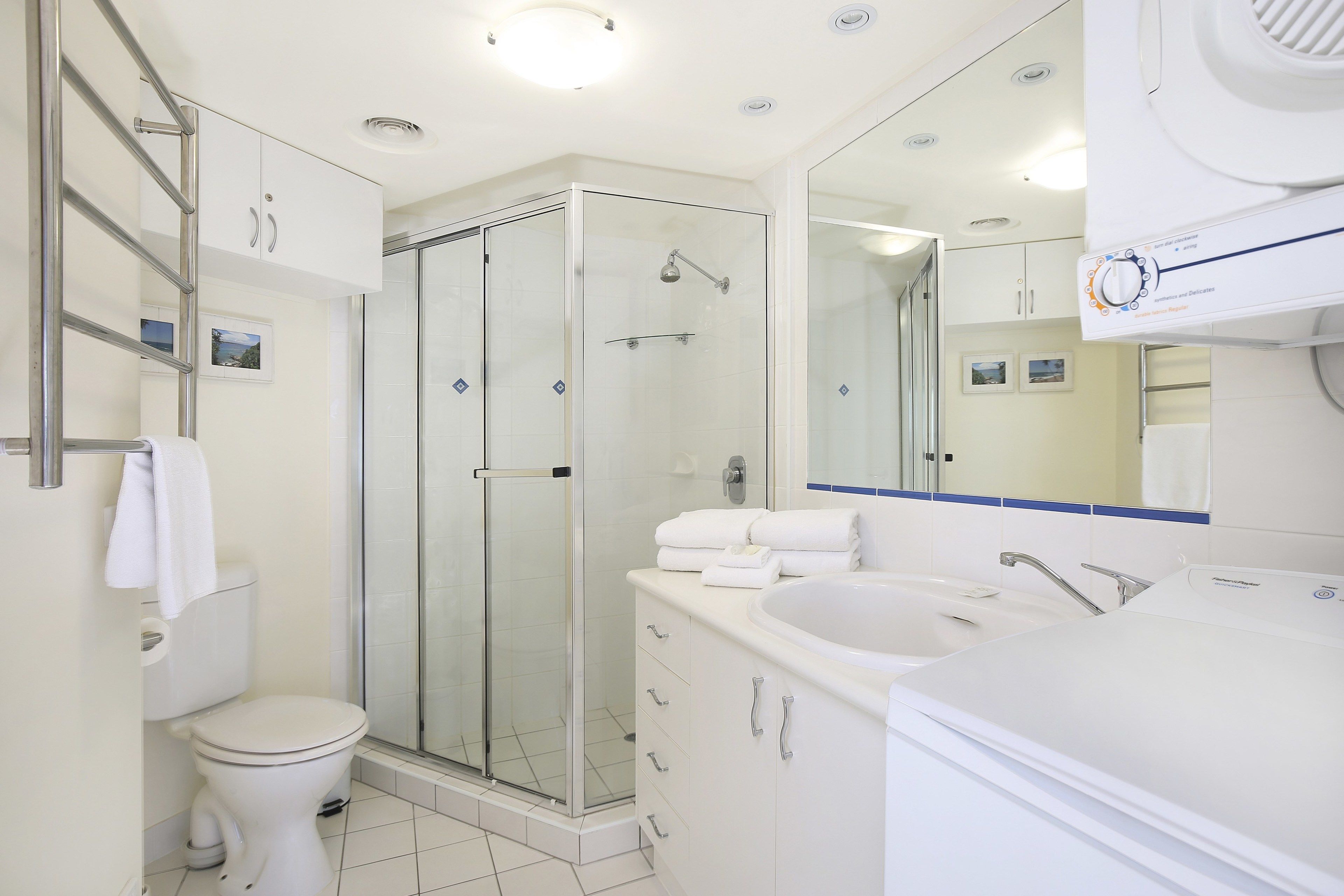 Une salle de bain moderne avec une douche à parois de verre, des toilettes, un lavabo et un meuble-lavabo avec des tiroirs.