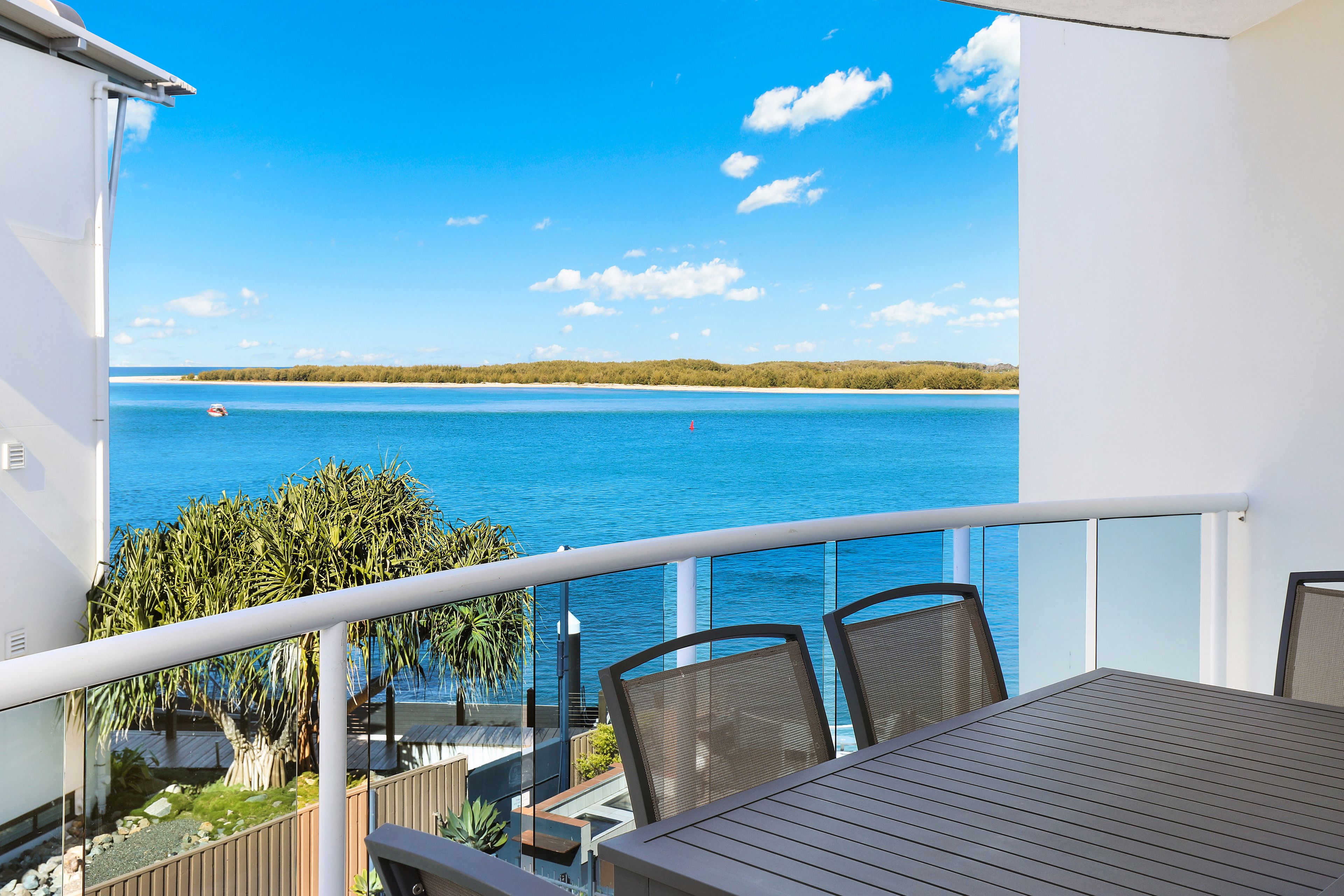 A balcony with a view of a large body of water and distant land.
