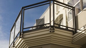 A modern building with a balcony, large windows, and a gated entrance. - Dunedin Palms Motel (Dunedin)