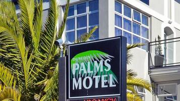 Señal del motel Dunes Palm con aviso de habitaciones disponibles.