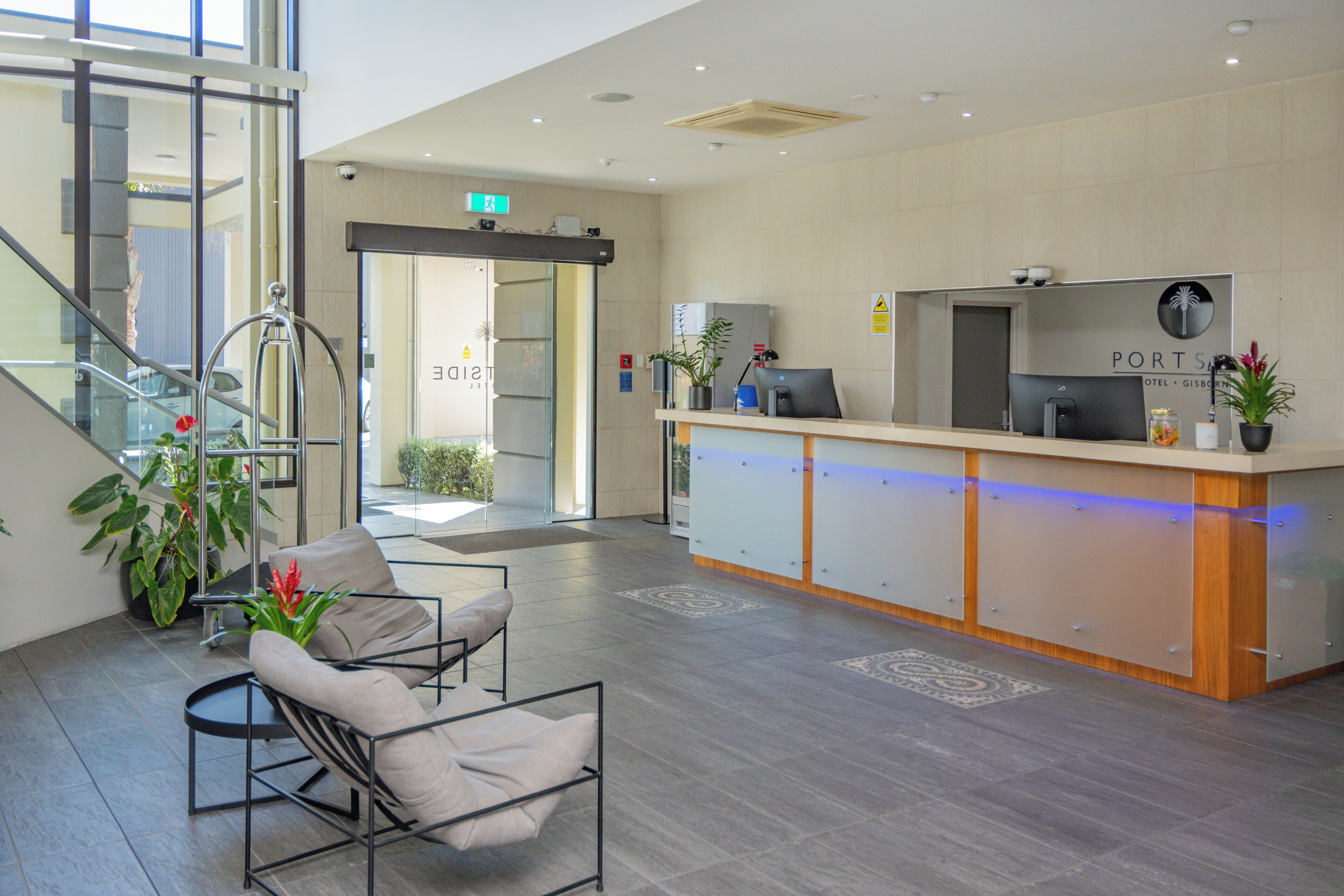 A reception area with a desk, chairs, and a staircase.