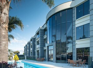 Ein modernes Gebäude mit Pool und Außenbereich zum Sitzen.
