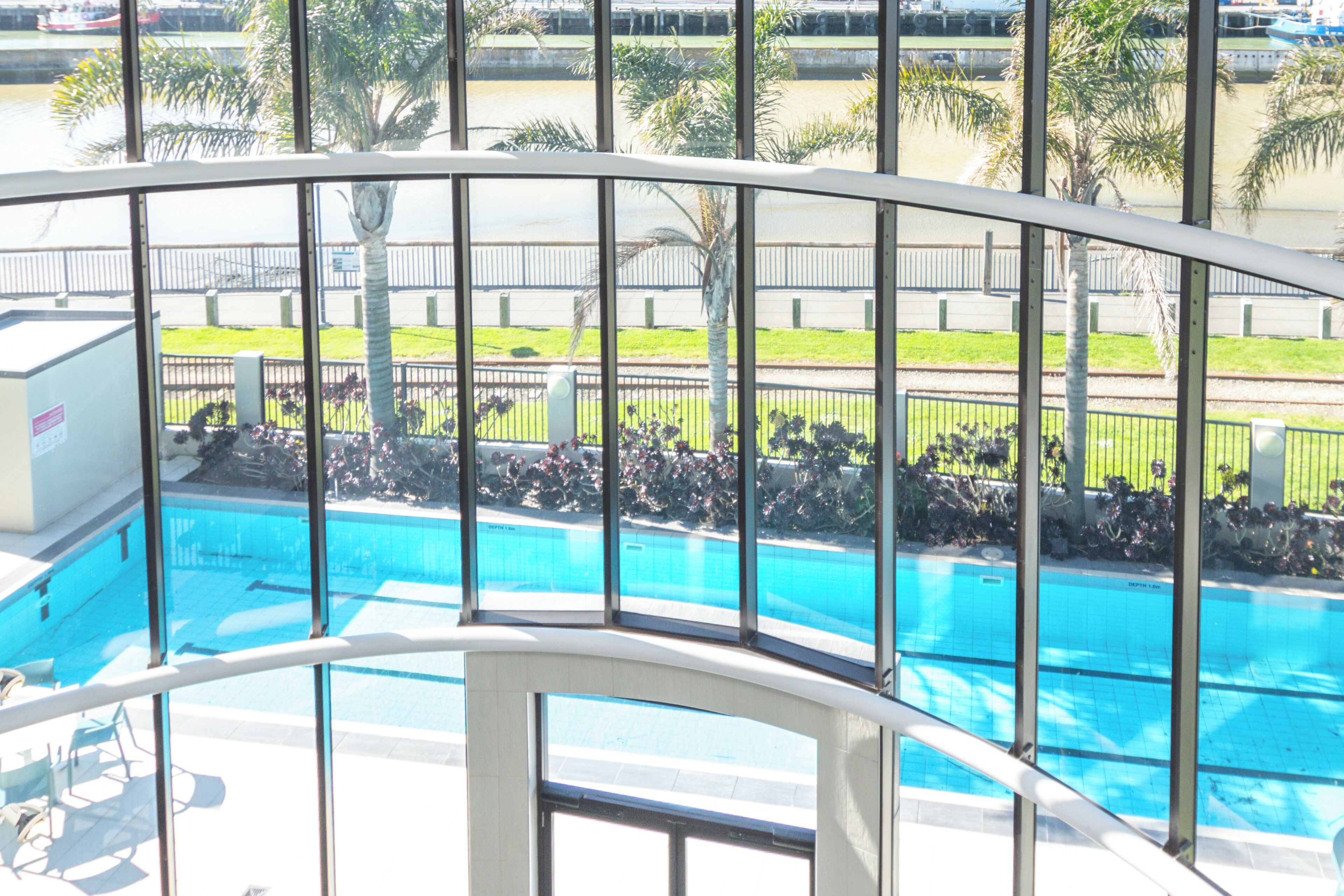 A pool area with a view of a road and parked motorcycles.