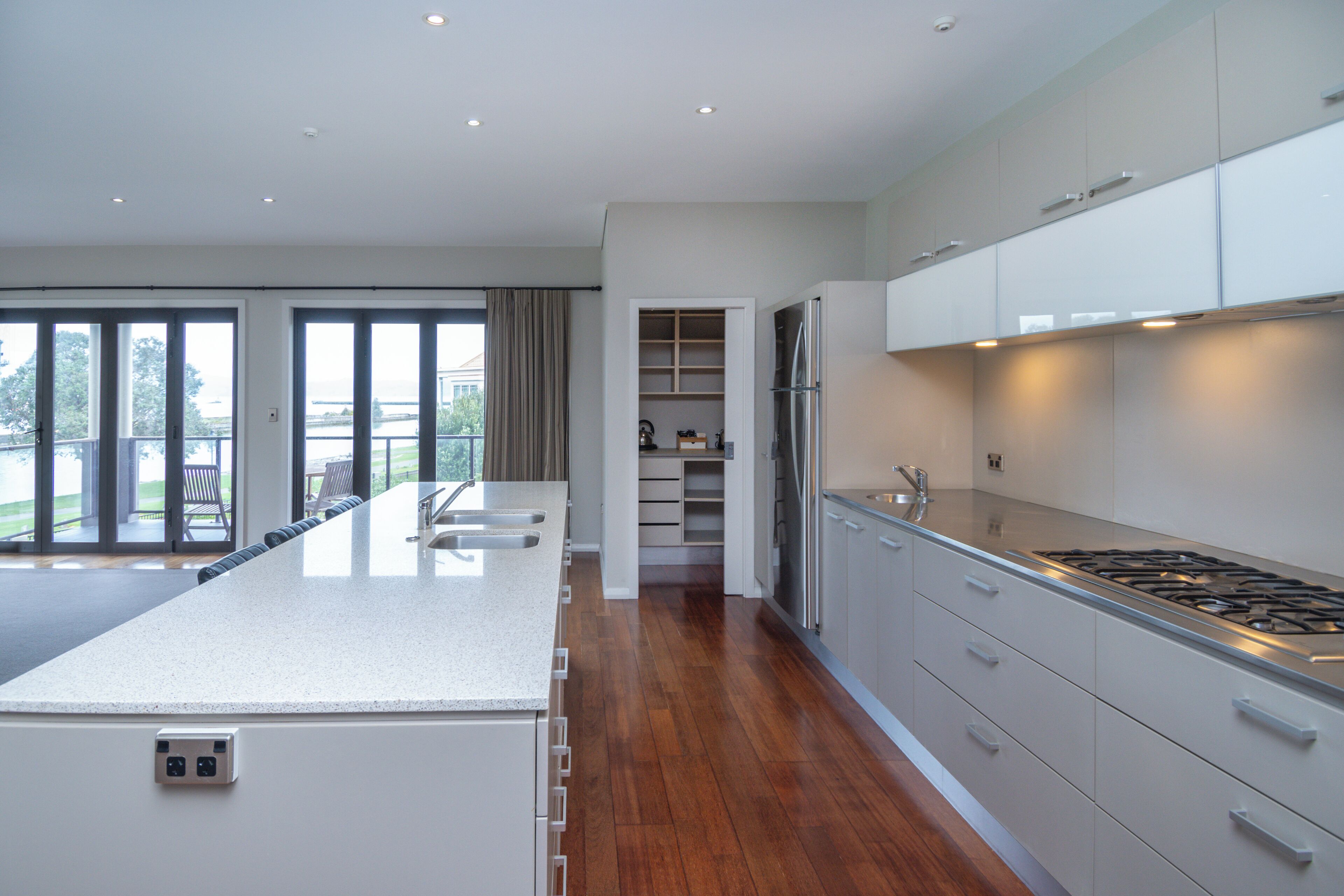 Una cocina moderna con una isla grande, electrodomésticos de acero inoxidable y vistas al exterior.