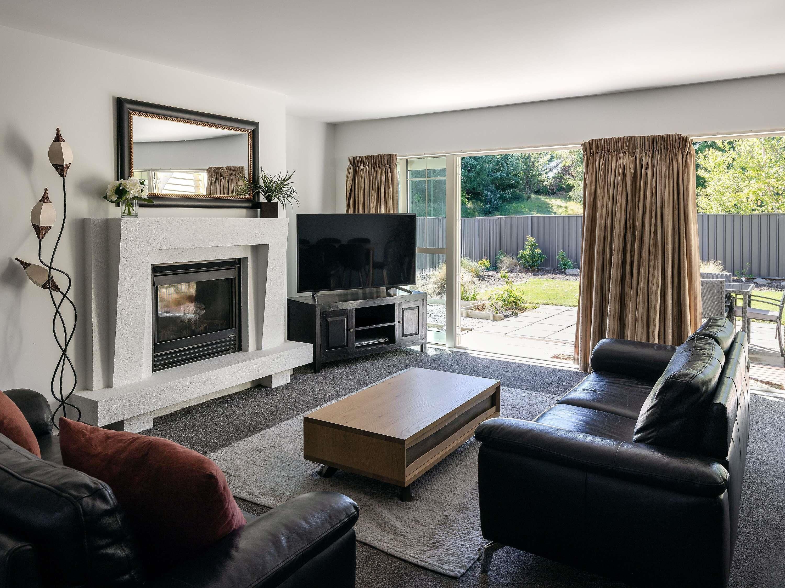 A living room with a fireplace, a television, a sofa, and a coffee table.