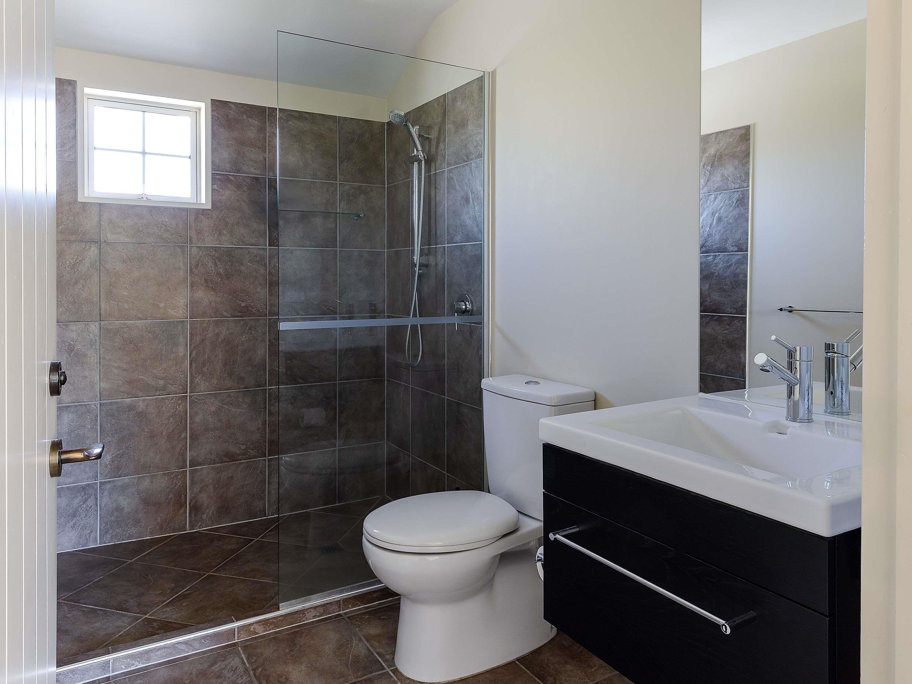 A bathroom with a shower, toilet, and sink.