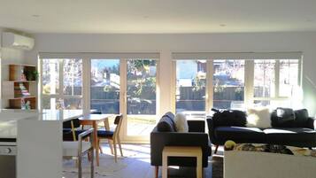 Una sala moderna con comedor, ventanas amplias y vista al jardín.