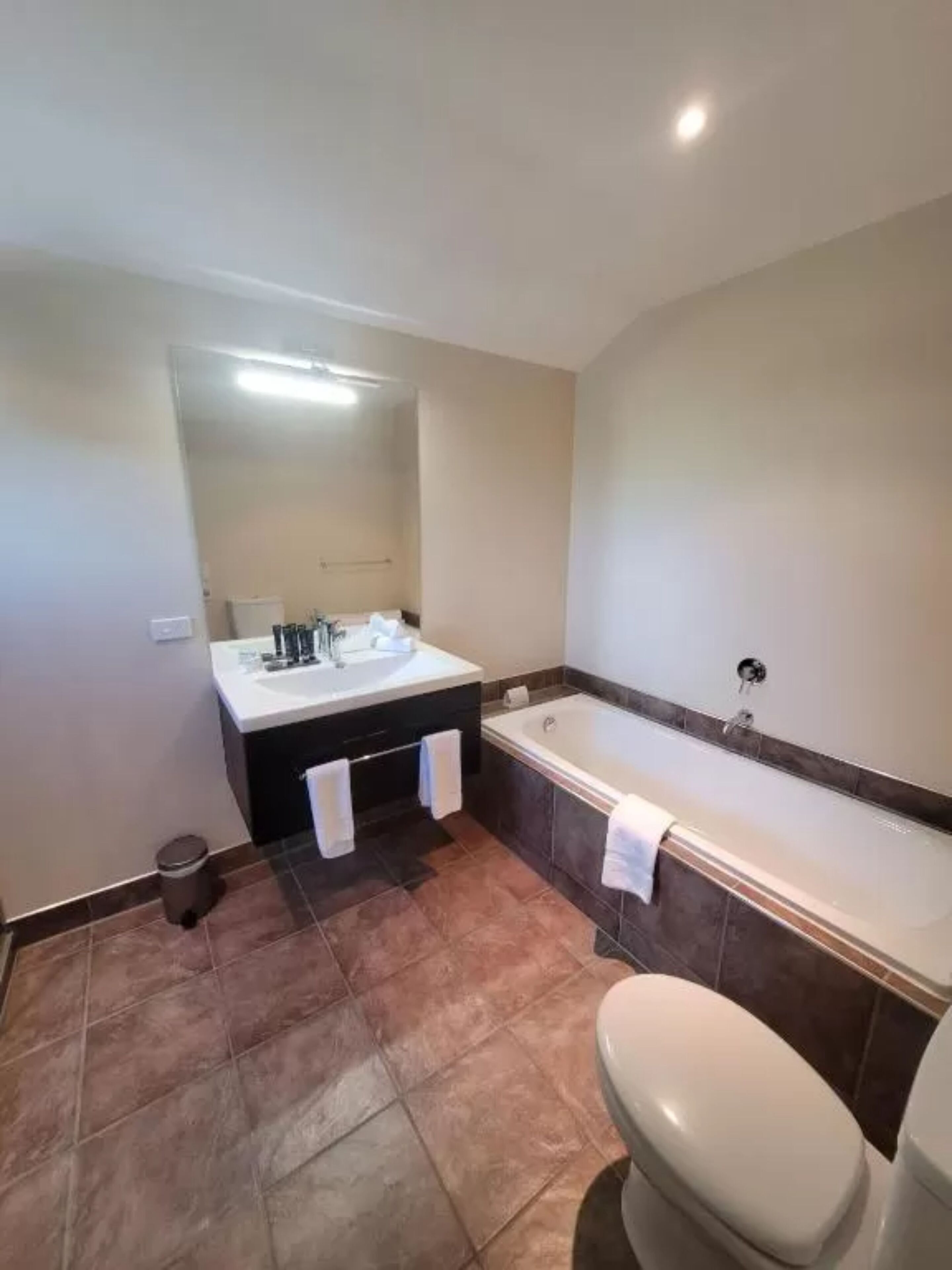 A bathroom with a bathtub, toilet, and sink.