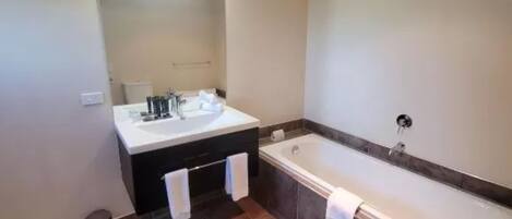 A bathroom with a bathtub, toilet, and sink.