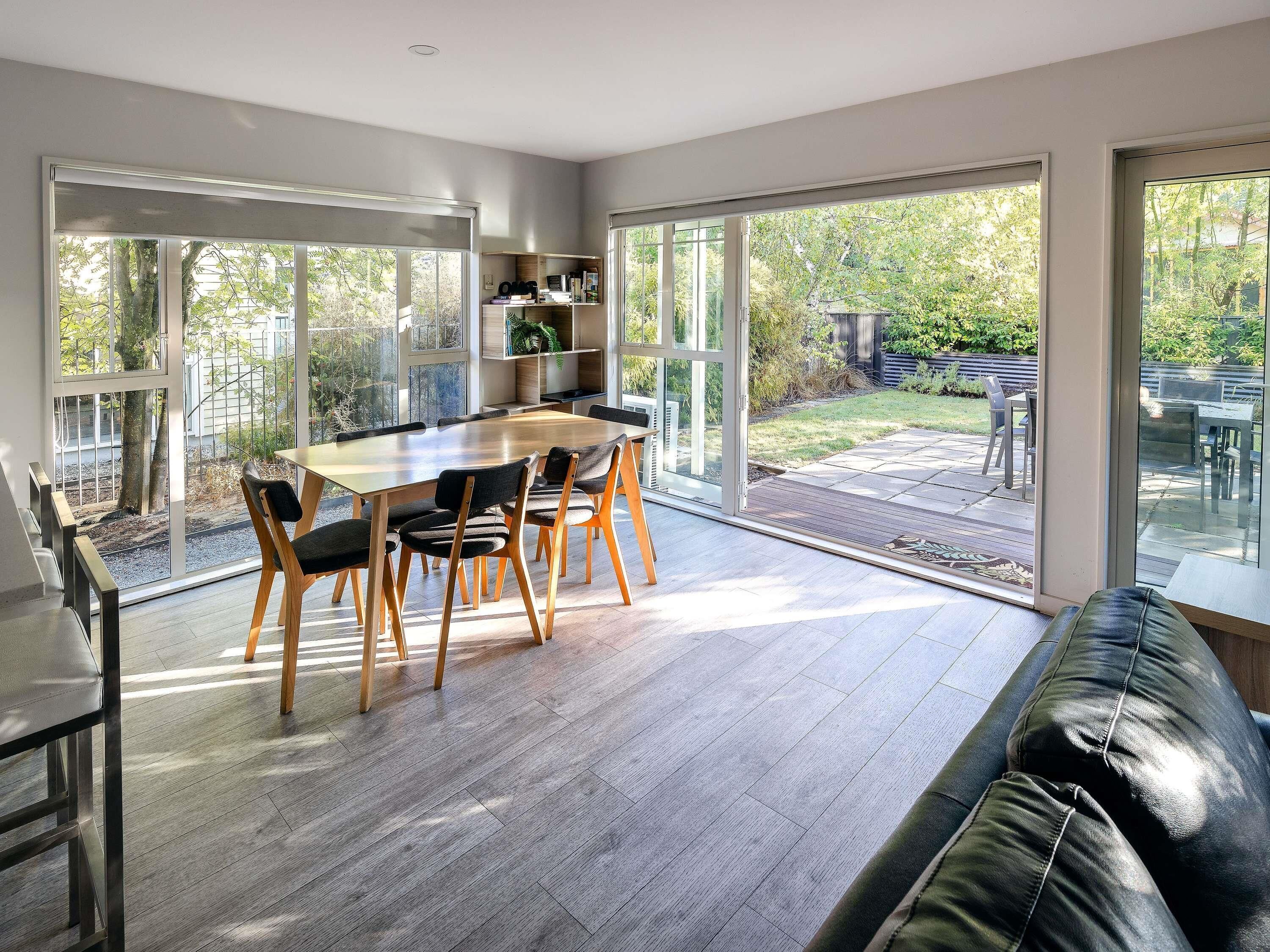 Una cocina moderna con comedor, ventanas amplias y vista al patio trasero.