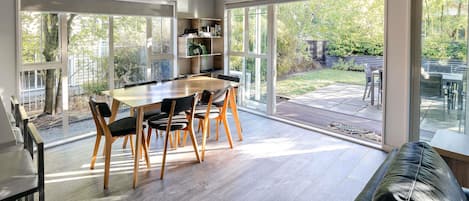 Una cocina moderna con comedor, ventanas amplias y vista al patio trasero.
