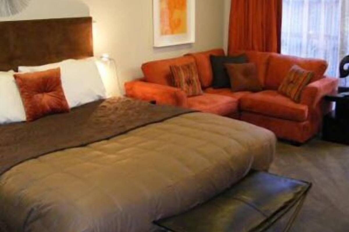 Een hotelkamer met een bed, een bank en een kleintje tafel.