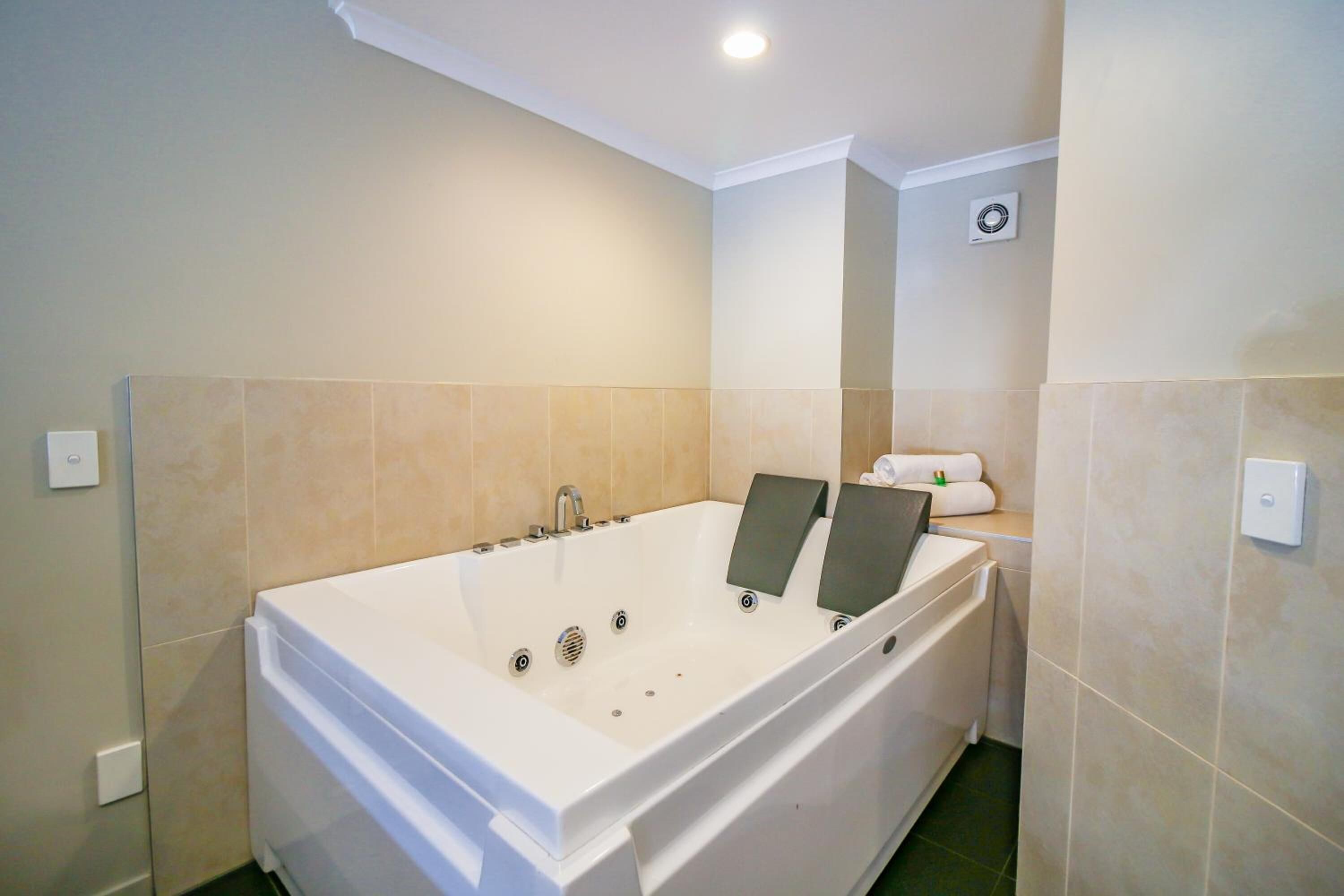 A modern bathroom with a large bathtub, a toilet, and a shower area.