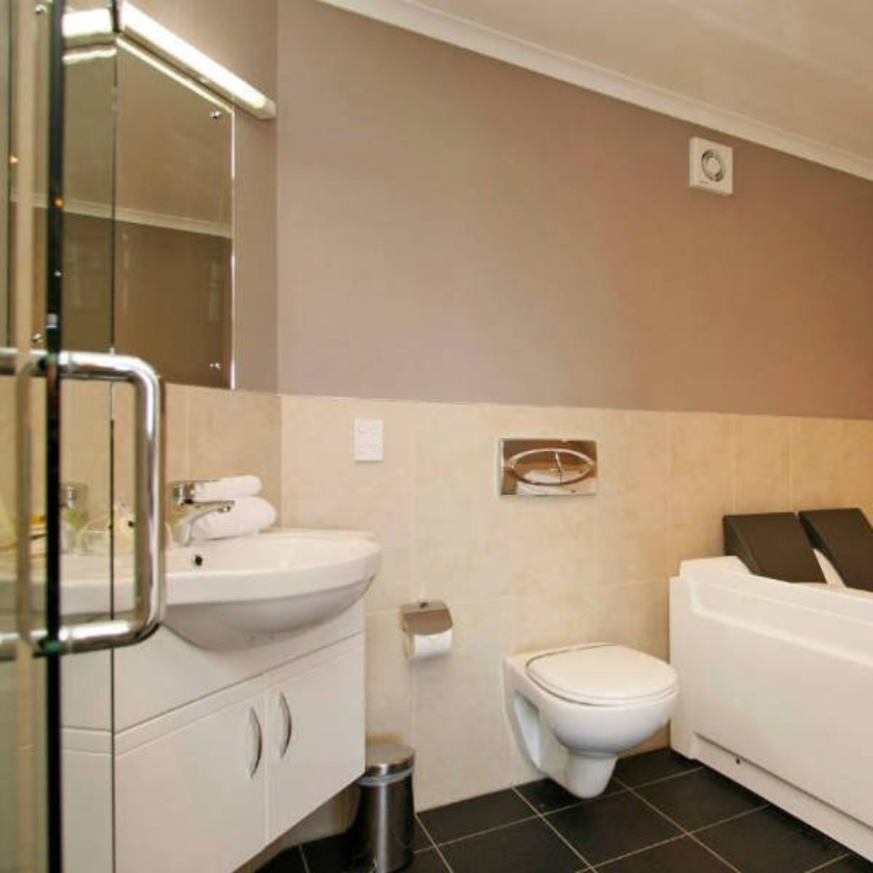 Un baño con lavamanos, inodoro y bañera blancos.