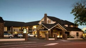 A hotel with a stone facade, multiple stories, and a prominent entrance with a roof over the lobby area. - Aotea Motor Lodge (Whanganui)