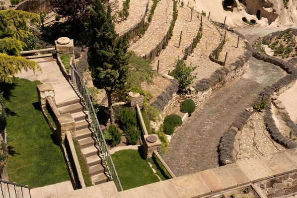 A terraced garden with stone steps and pathways, surrounded by greenery and trees. - Argos in Cappadocia (Nevsehir)