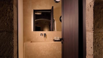 Ein schmaler Flur führt zu einem Badezimmer mit Badewanne, Handtuchhalter und einer Leuchte.