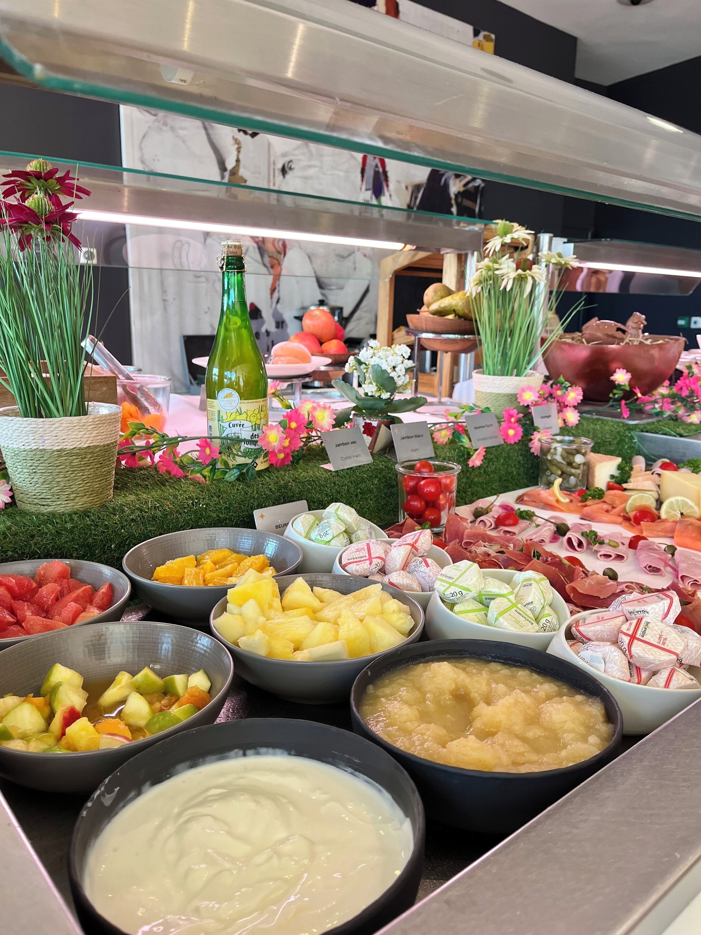 A buffet with various food items and a bottle of green wine.