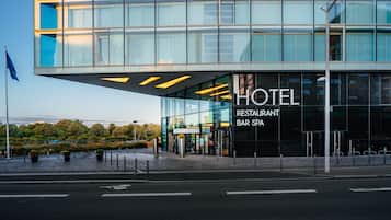 Ein modernes Hotel mit Glasfassade, beschriftet mit: „HOTEL RESTAURANT BAR SPA.“