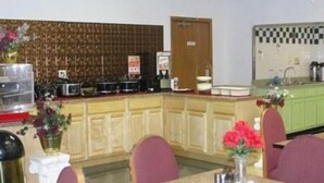 A restaurant with a counter, chairs, and a table. - Royal Inn Knoxville Airport Alcoa (Alcoa)