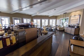 A spacious hotel lobby with a large reception desk, multiple seating areas, and large windows providing natural light.