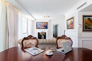 A conference room with a wooden table, two upholstered chairs, a laptop, a smartphone, a cup of coffee, and a newspaper.