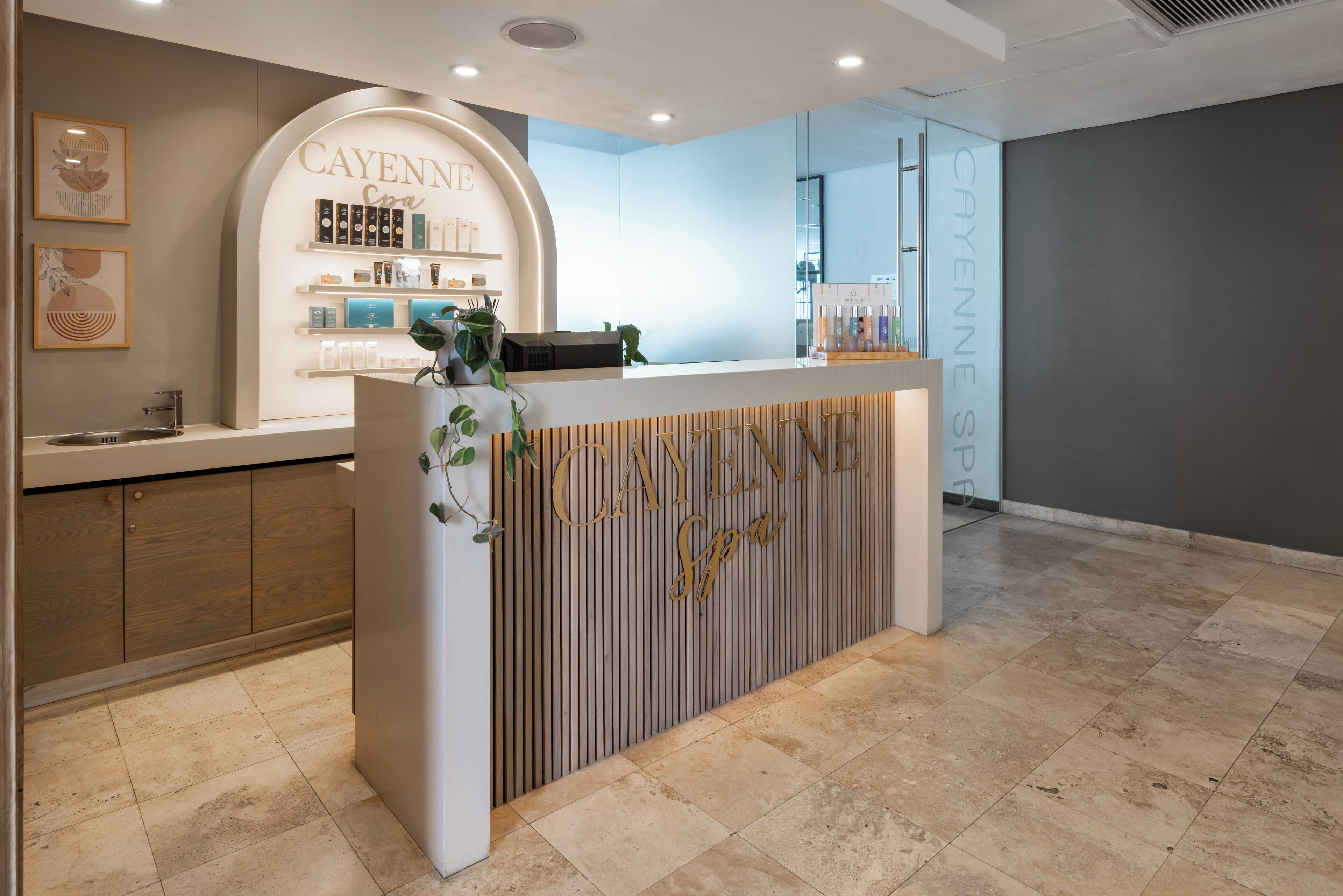 A reception area with a counter displaying 'CAYENNE Spa' branding, a wooden panel design, and a modern interior.