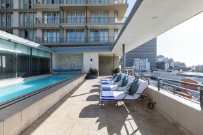 Alberca al aire libre y camastros 