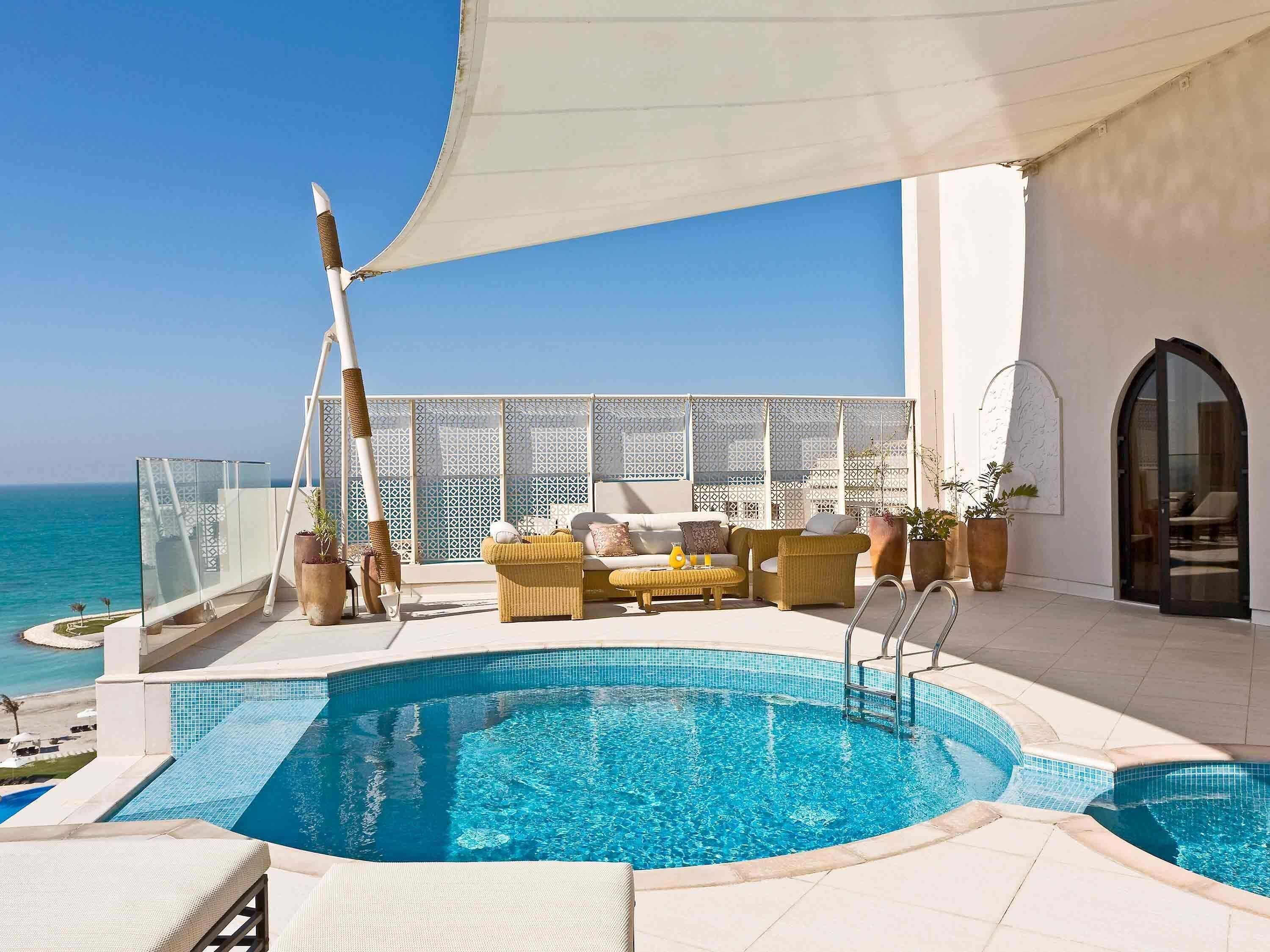 Una piscina al aire libre, tumbonas