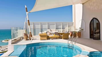 Una piscina al aire libre, sillones reclinables de piscina