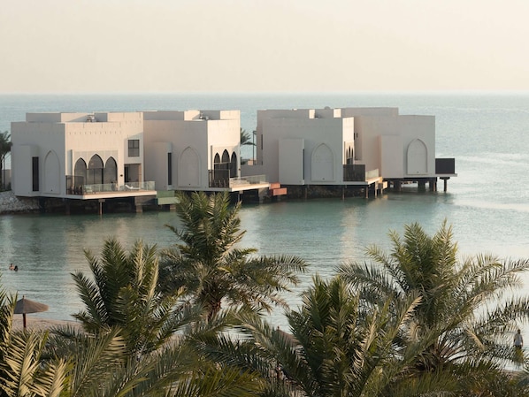 Un hotel frente al agua con varias edificaciones, cada una con ventanas arqueadas y balcones.