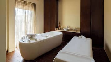 Bathroom features a bathtub, wooden floor, and large mirror.