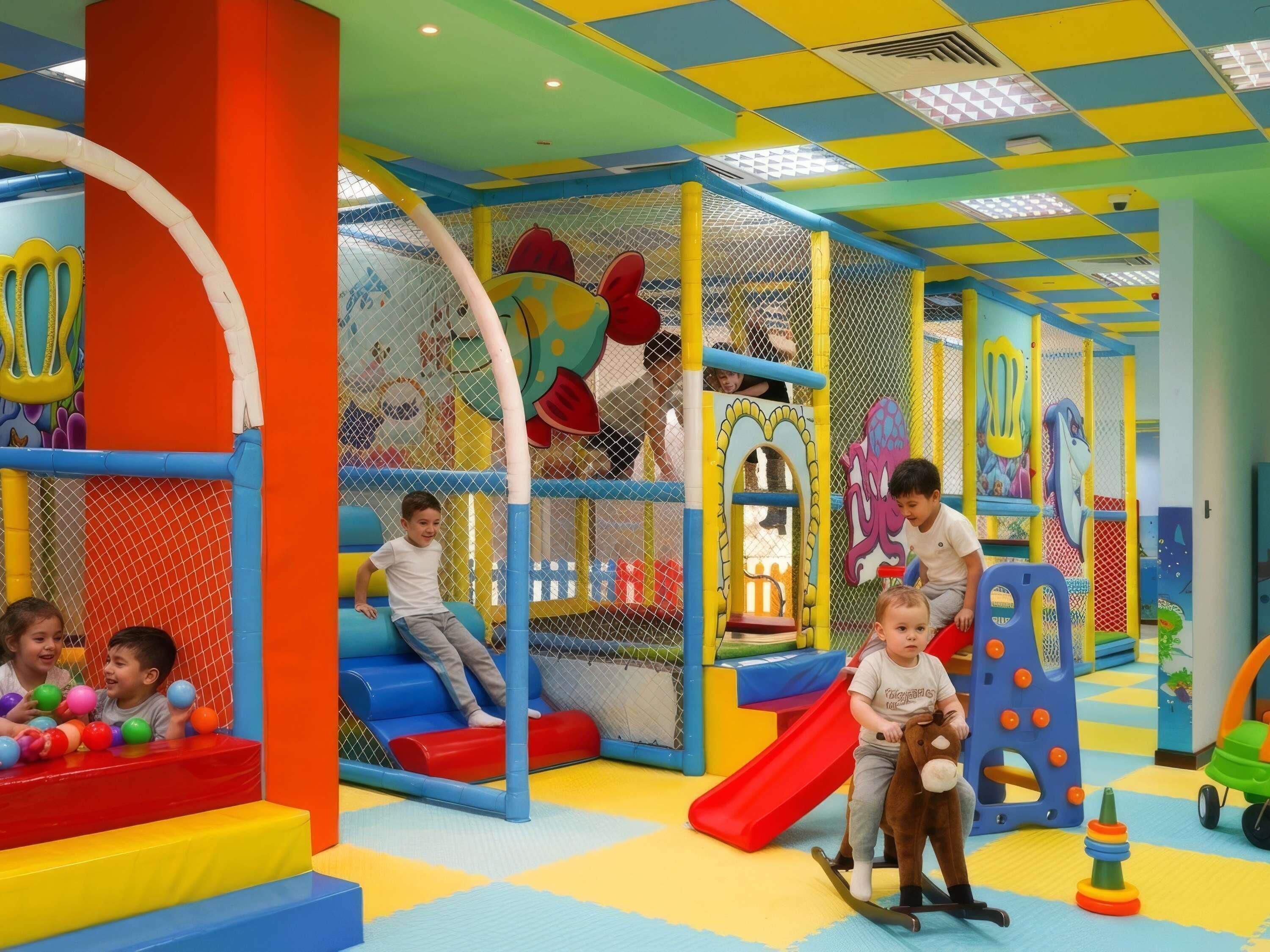 A play area with slides, climbing structures, and soft play surfaces.