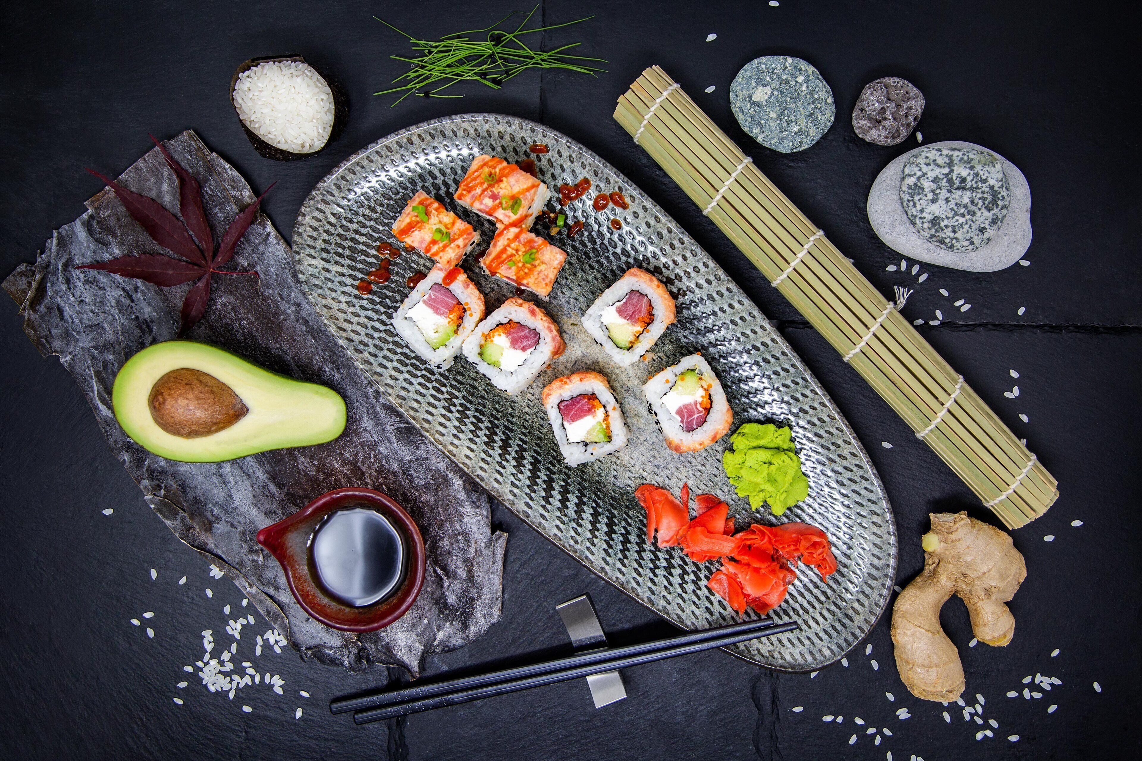 A sushi platter with various types of sushi, including nigiri and sashimi, accompanied by wasabi, pickled ginger, and a small bowl of soy sauce.