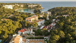 Luchtbeeld van een kustresort met een zwembad, villa’s en een strand.