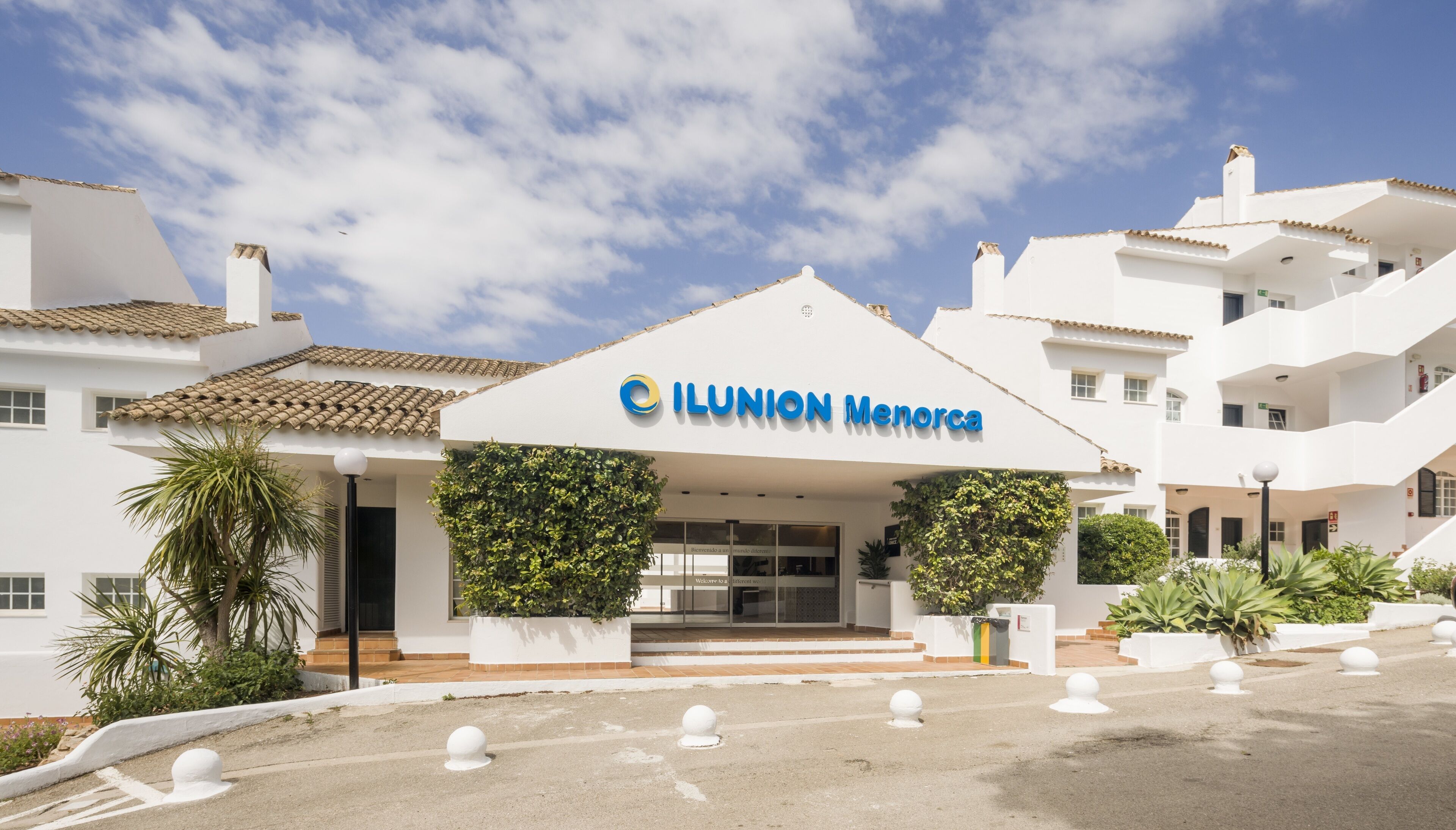 En hotellentrédörr med en skylt som visar texten ”ILUNION MENORCA”.