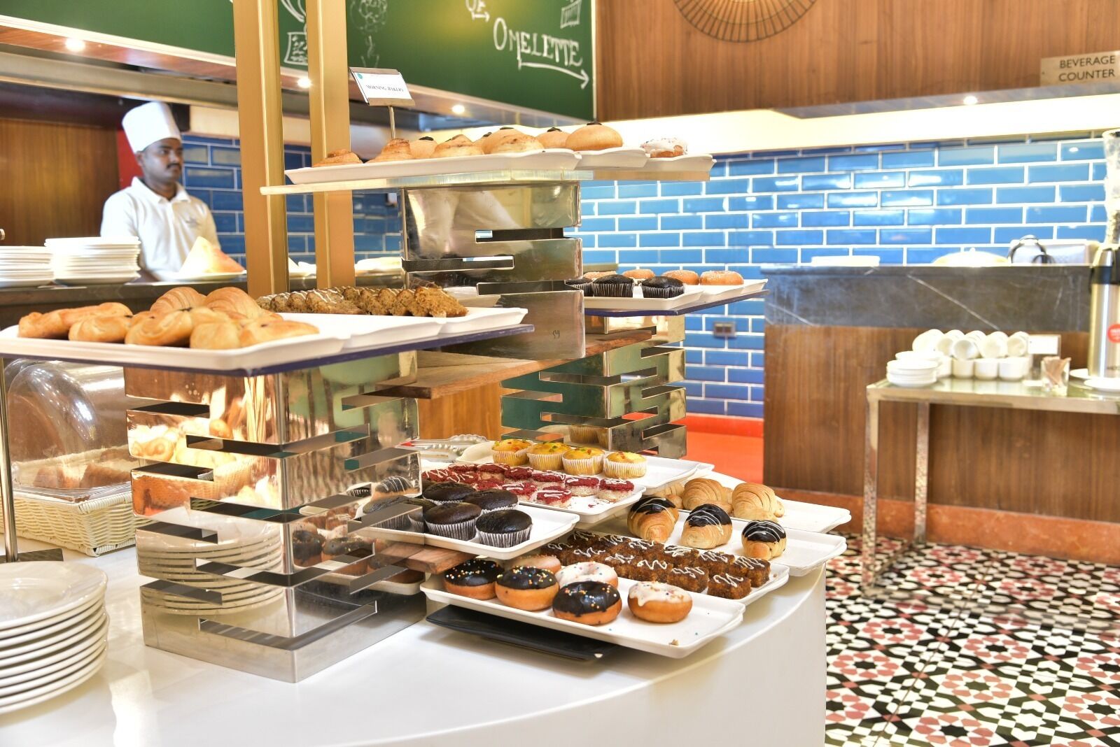 Ein Frühstücksbuffet mit einer Auswahl an Gebäck und Backwaren an verschiedenen Servicestationen.