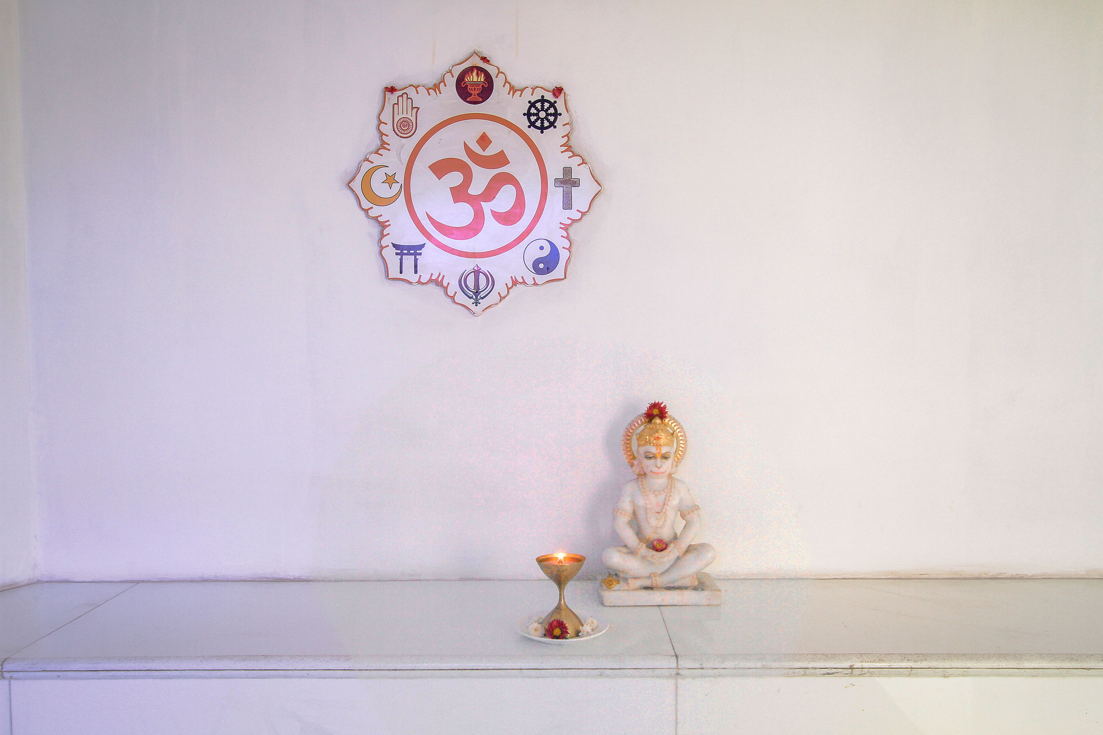 A wall with a religious symbol and a statue.