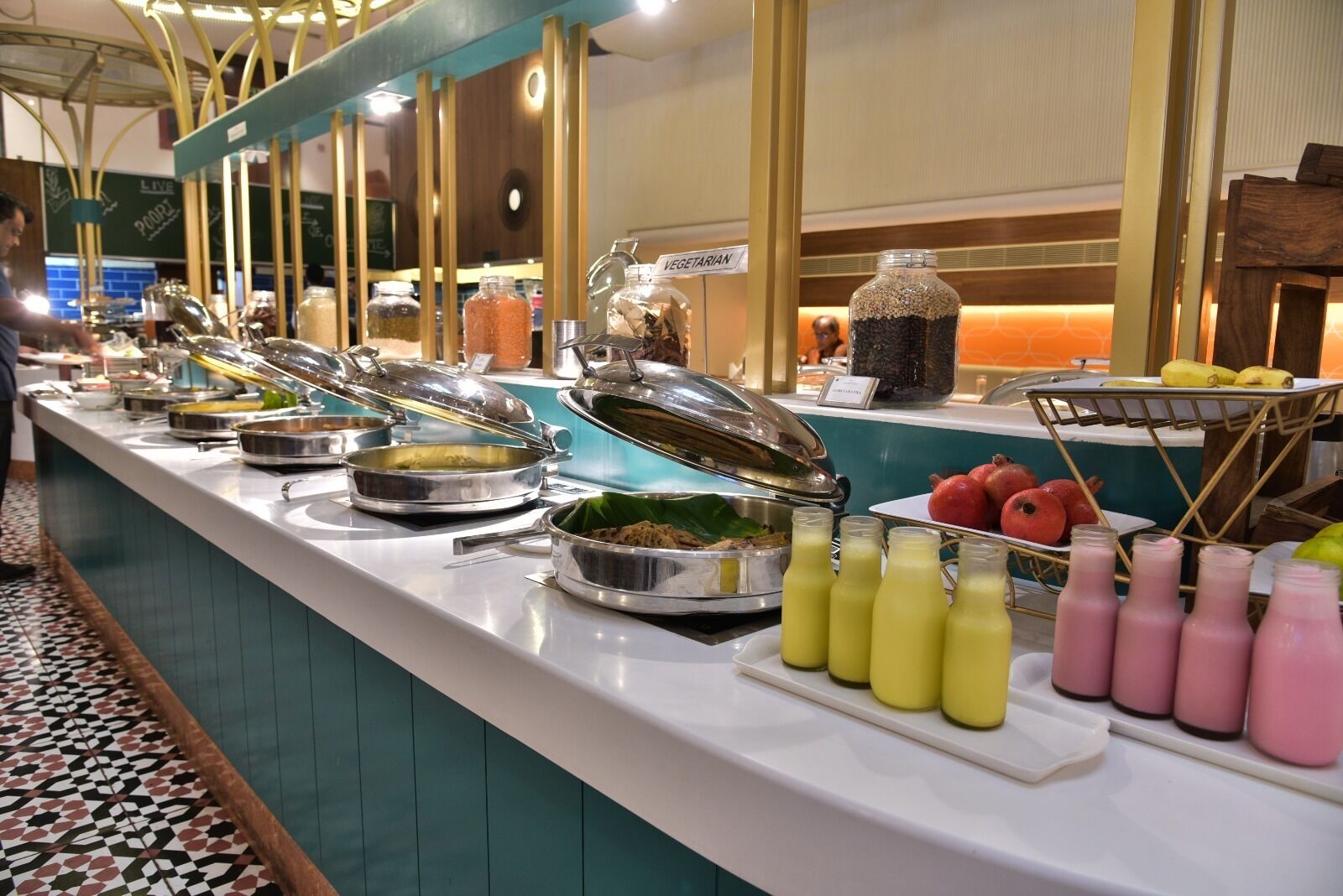 Un bufé con diferentes opciones de comida y bebidas, incluyendo una sección con menú vegetariano.