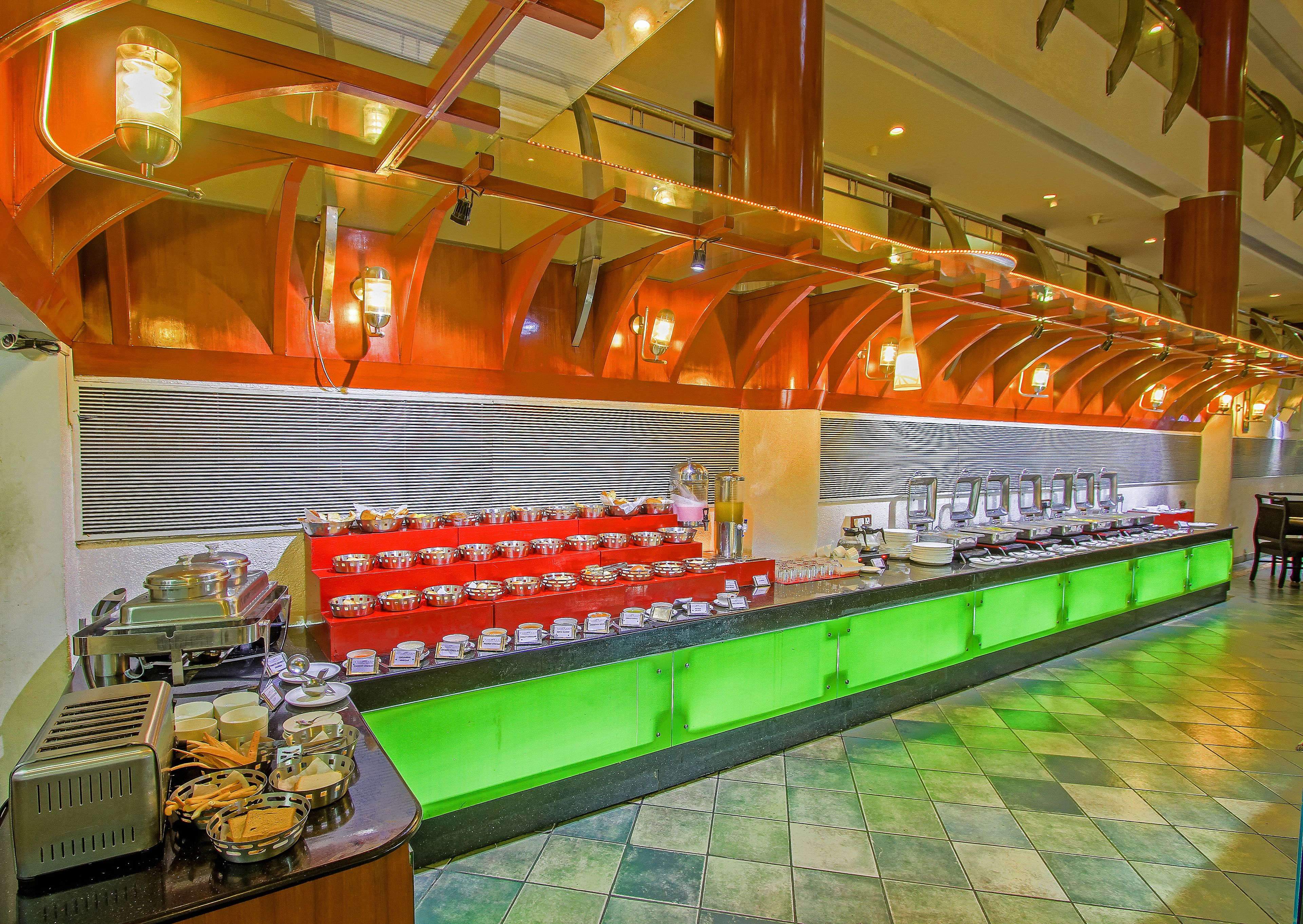 Uma mesa de buffet com diversas estações de comida e um balcão iluminado.